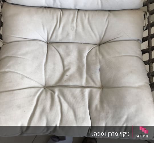 כרית ישיבה מלוכלכת עם כתמים קטנים